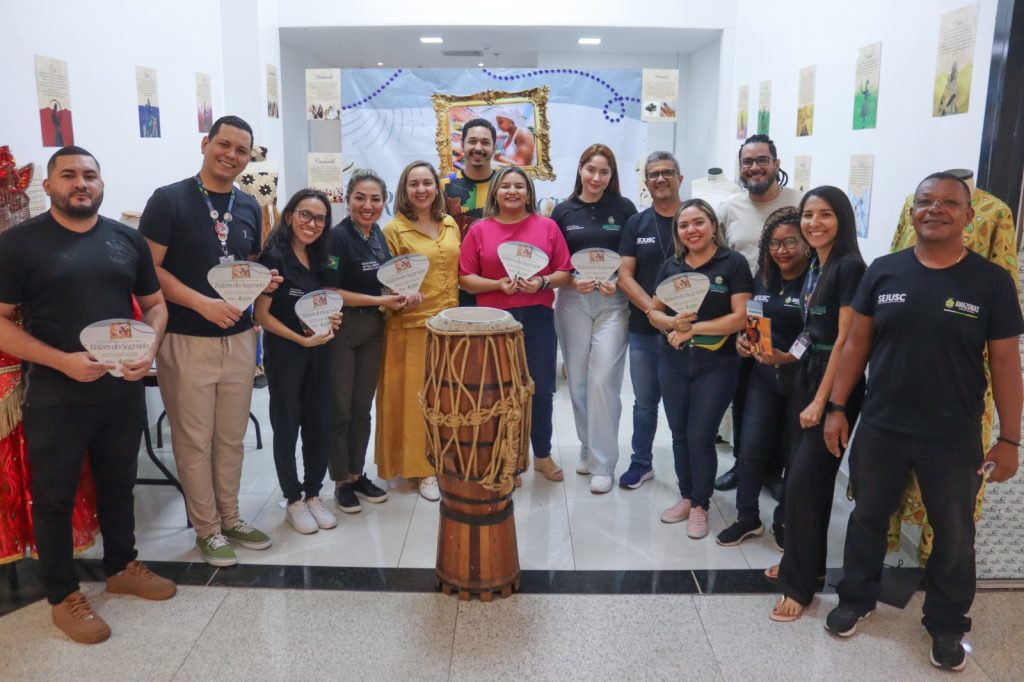 Raízes do Sagrado: Governo do Amazonas realiza exposição sobre religiões de matriz africana em shopping da zona leste Informe Manaus Sejusc Secretaria Jussara Pedrosa de rosa no centro e equipe de Direitos Humanos Fotos Ygson Franca 1 1024x682 1
