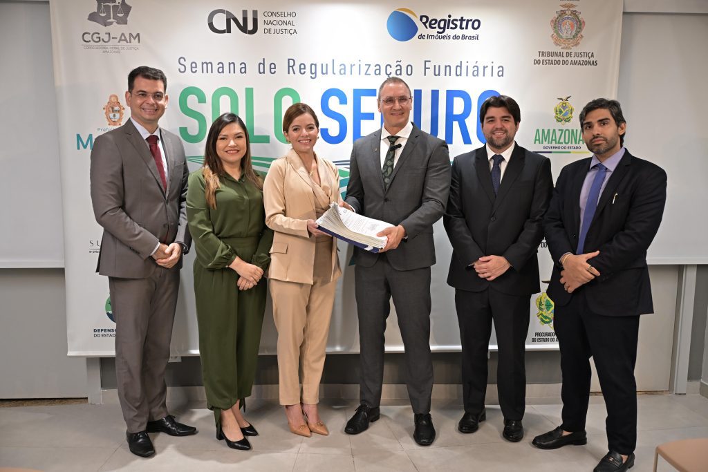 Títulos definitivos: Sect avança na regularização fundiária na zona norte de Manaus 5 SECT secretaria da Sect ao lado do tabeliao do Cartorio e as demais representantes de entidades publicas Divulgacao 1024x683 1